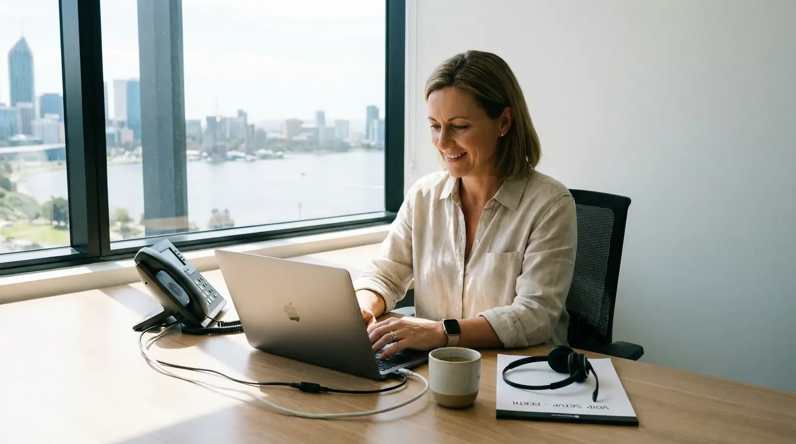 A small business owner in Perth setting up their VoIP phone system on a laptop.
